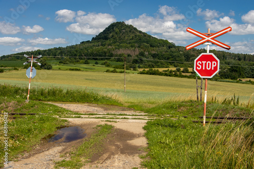 A red STOP sign before crossing the tracks, Czech Central Highlands. photo