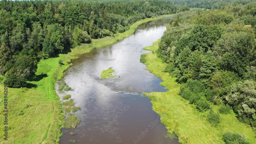 Aerial shot flying along river. River sorrounded by green forest Aerial shot flying along river. River sorrounded by green forest