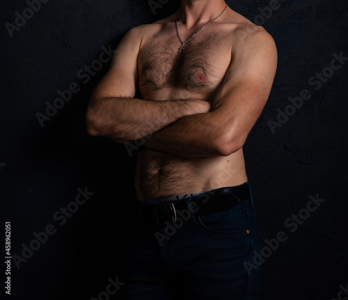 Canvas Print A naked torso with hair of an ordinary man in good physical shape in jeans on a dark background