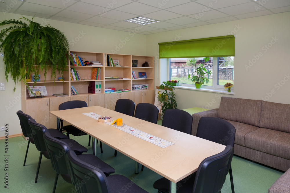 Modern day care nursery or pre-school, spacious interiors, room with tables and chairs Modern day care nursery or pre-school, spacious interiors, room with tables and chairs