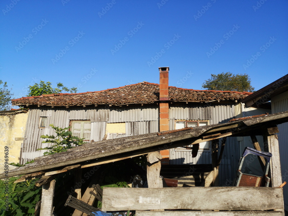 Φωτογραφία Baufälliger alter Schuppen vor blauem Himmel im Sommer bei Sonnenschein in einem