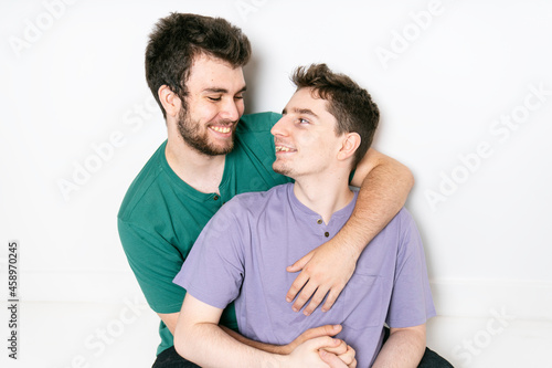 Young gay couple standing together over isolated background