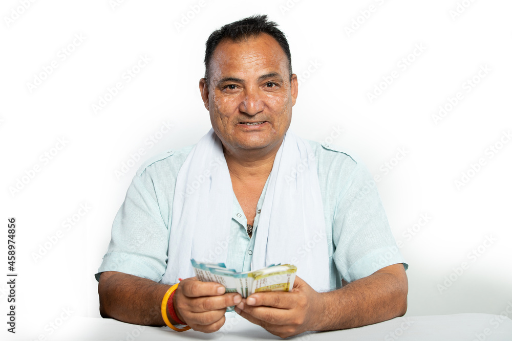 Indian Farmer mid aged man smiling with cash in hand white background Indian Farmer mid aged man smiling with cash in hand white background