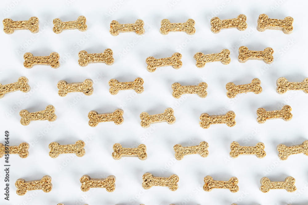 Dry pet food in the form of a bone on a white background. Pattern. Dry pet food in the form of a bone on a white background. Pattern.