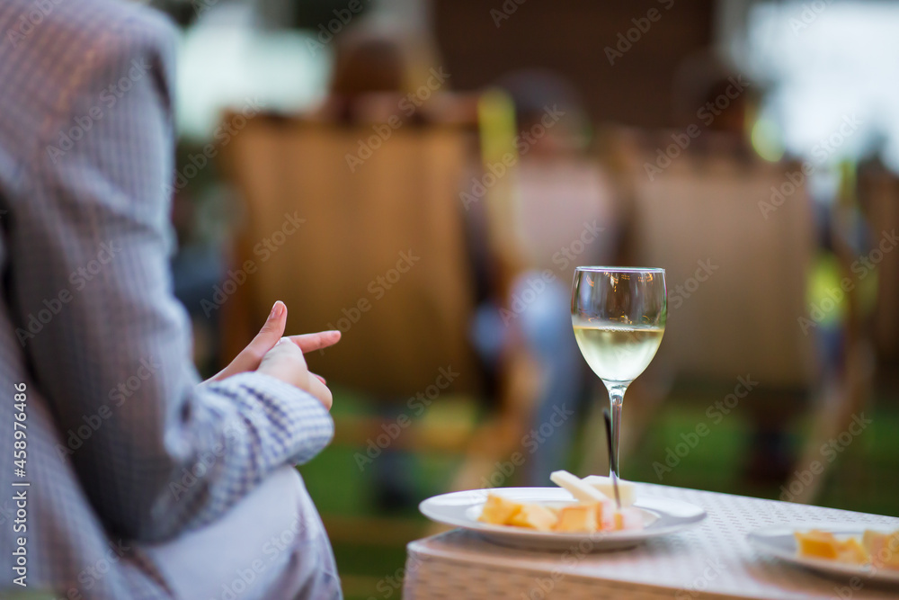 Girl drinking wine at the event. A glass of wine is on the table