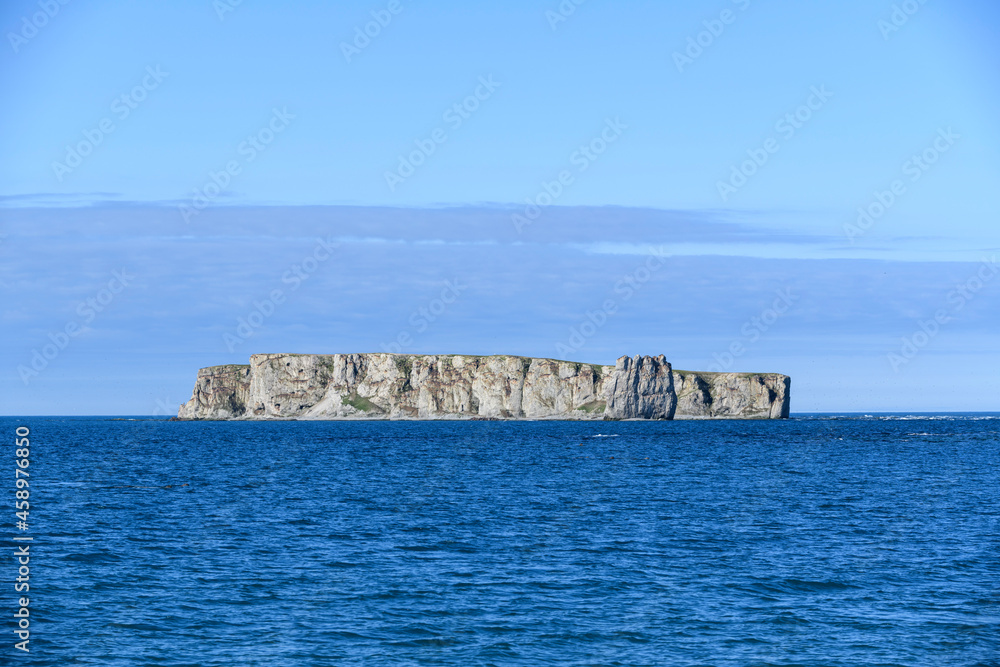 Flat island at sea. Arctic landscape in summer time. Franz Jozef Land archipelago.