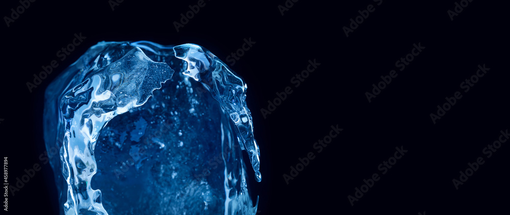 A piece of ice, frozen helmet on black background. Winter decorative element. copy space