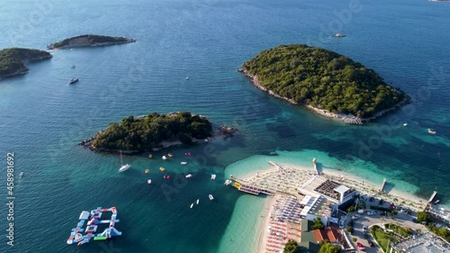 Aerial drone view of exotic beaches and beautiful islands at summer. Ionian sea in Ksamil, Albania. Seaside resort and hotels. Coastline. photo