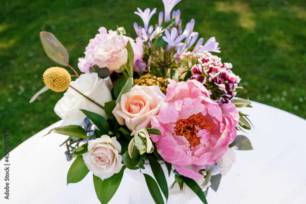 Bridal bouquet of pink peonies and pink and white roses Light white roses and pink peony beautiful wedding bouquet of fresh flowers on the white table with green background Close up Bridal bouquet of pink peonies and pink and white roses Light white roses and pink peony beautiful wedding bouquet of fresh flowers on the white table with green background Close up