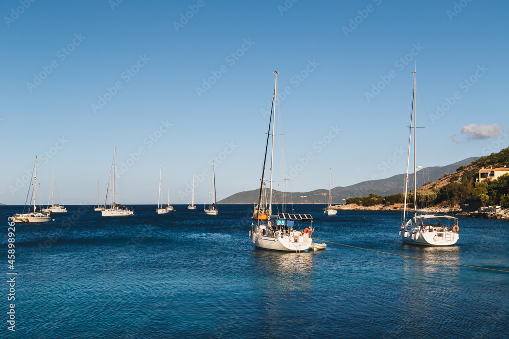 White yachts anchored in blue bay of Agia Efimia port, Cephalonia island, Greece.