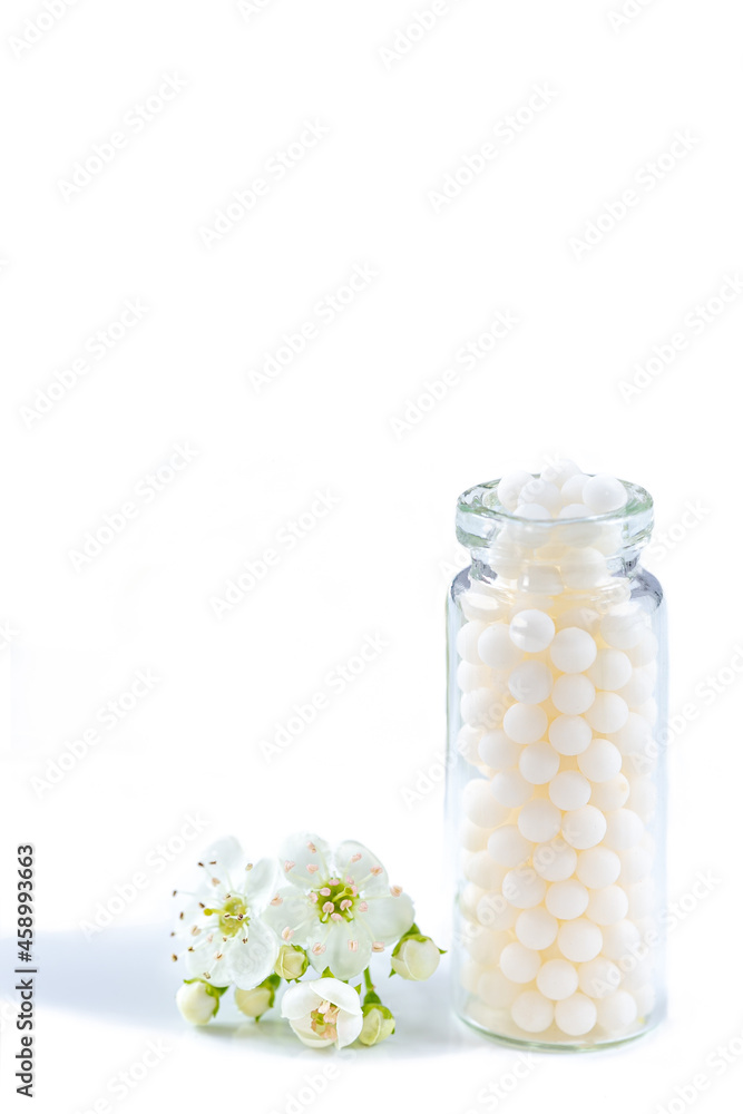 Homeopathic granule in glass bottle with white flower. Homeopathic granule in glass bottle with white flower.