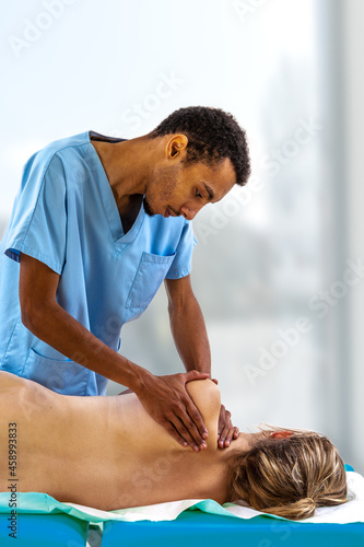 Close up of physiotherapist manipulating young woman. Girl laying on spa bed with hands massaging.