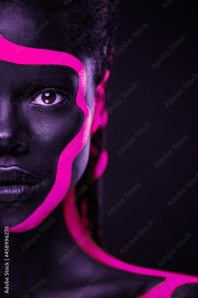 Neon colors. Pink and black body paint. Woman with face art. Young girl  with colorful bodypaint. An amazing afro american model with makeup. Stock  Photo