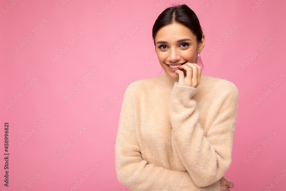 Portrait of young positive happy adorable smiling beautiful brunette woman with sincere emotions wearing casual beige jersey isolated over pink background with free space Portrait of young positive happy adorable smiling beautiful brunette woman with sincere emotions wearing casual beige jersey isolated over pink background with free space