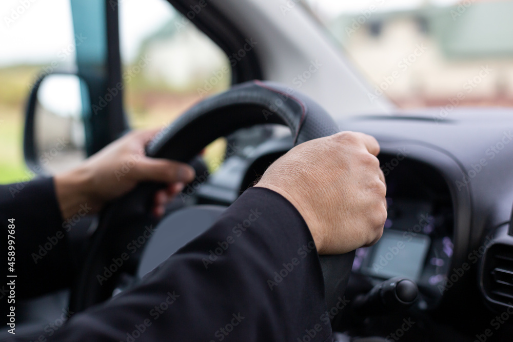 Man's hands at the wheel of a car. Safe driving. Drunk driving. Falling asleep behind the wheel.