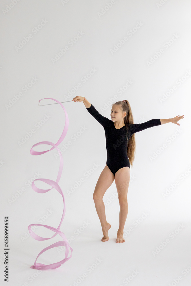 slim artistic teenager girl in black leotard trains on white background