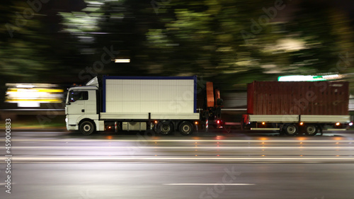Duży samochód ciężarowy w drodze z dostawą nocą w mieście.
