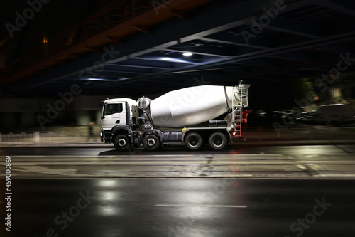 Duży samochód ciężarowy betoniarka w drodze na budowę nocą w mieście. 