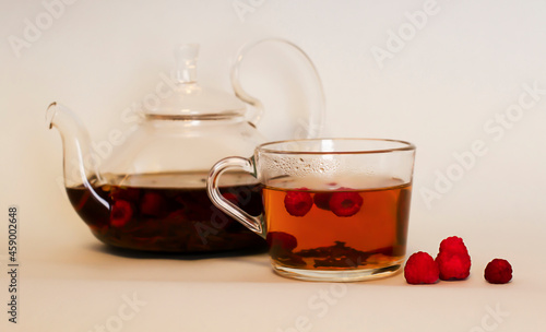 mug with hot raspberry tea and a teapot