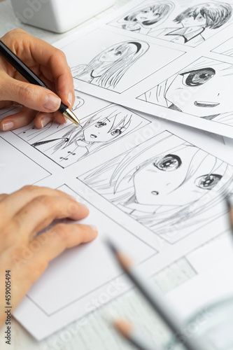 The artist draws anime comics on paper. Storyboard for the cartoon. The illustrator creates sketches for the book.