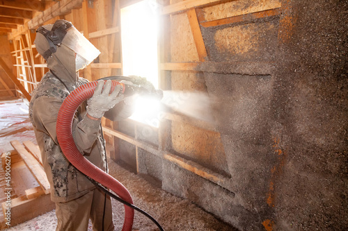 Spraying cellulose insulation on the wall. Application with added water