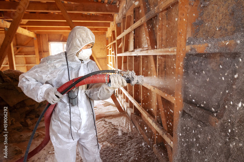Insulation of a frame house. Spraying cellulose insulation on the wall. photo