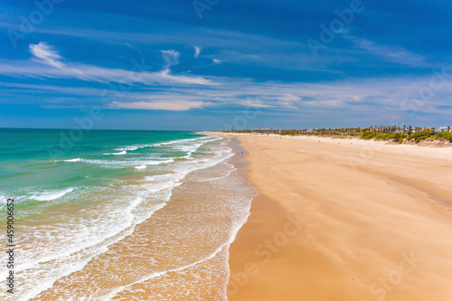 Aerial view of the beach of Playa La Ballena with a long sandy shoreline and turquoise waters in Cadiz, Andalusia, Spain.