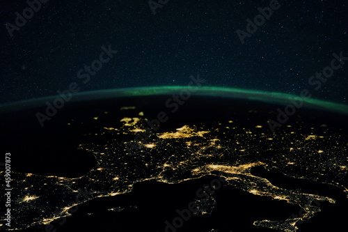 Night planet earth with the lights of megalopolis cities at night and the northern lights. Europe and the cities of Italy, France, Spain and Germany, view from space.