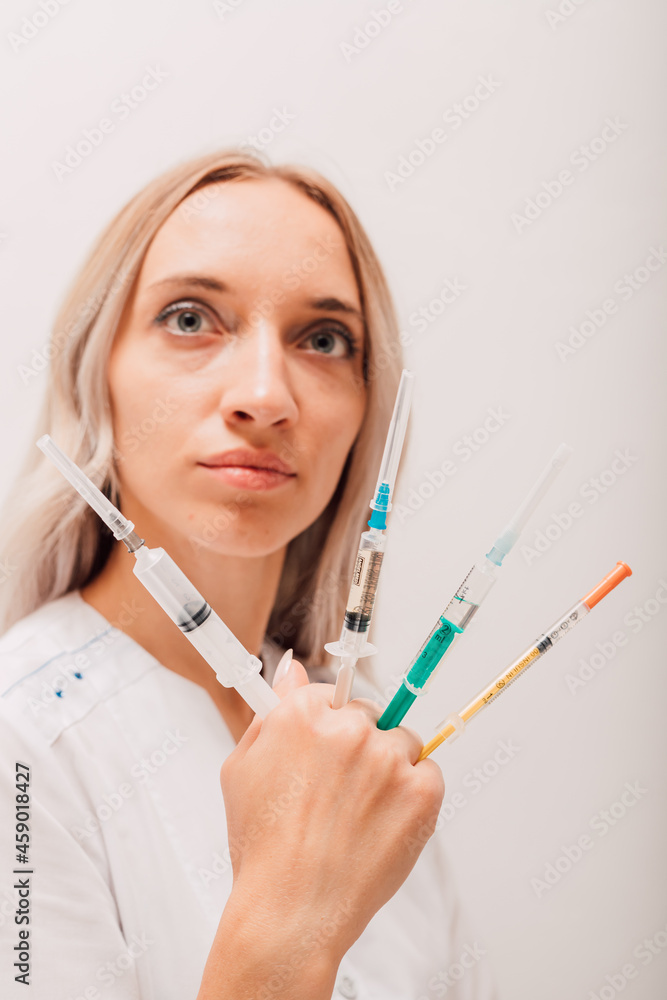 Young nurse holding many syringes with covid vaccine in her hands
Young nurse holding many syringes with covid vaccine in her hands