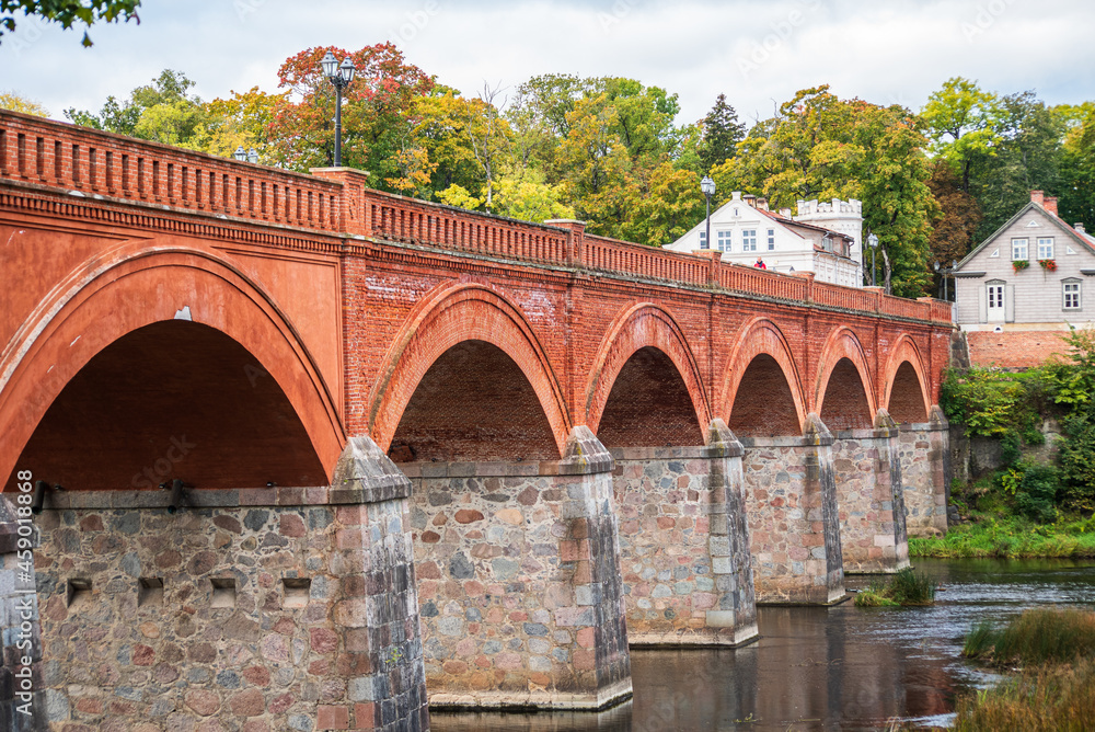 Long red brick bridge in sunny autumn morning, Kuldiga, Latvia.
