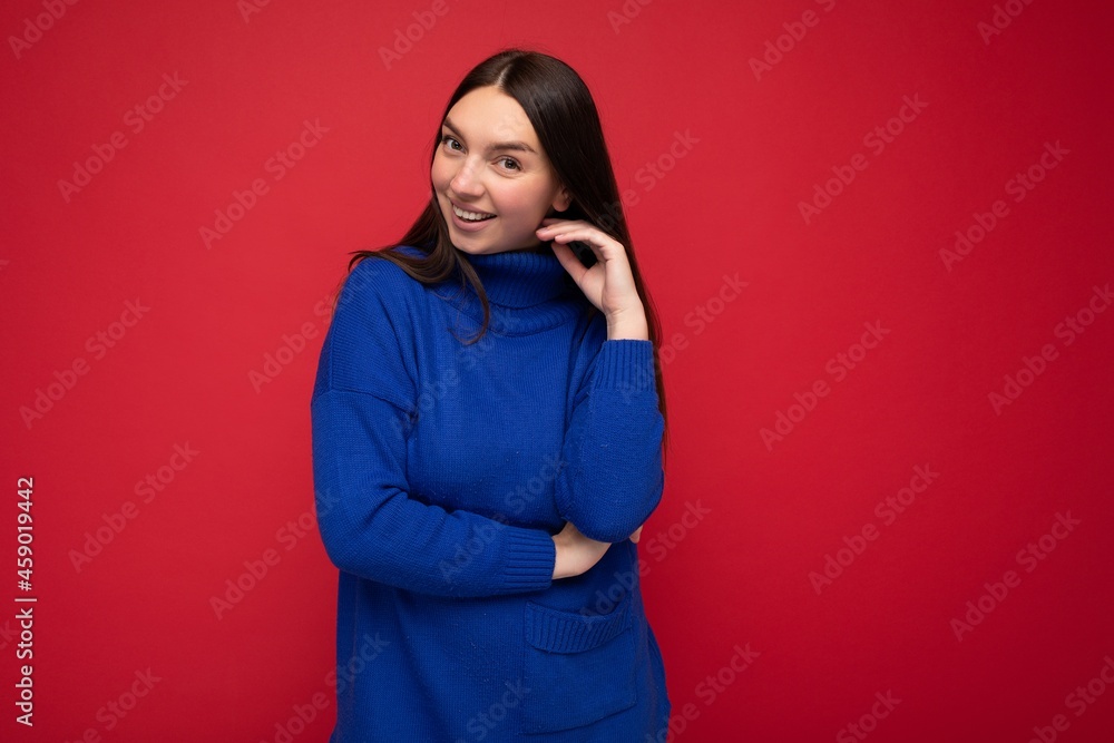 Fototapeta premium Young attractive brunette woman with sincere emotions isolated on background wall with copy space wearing casual trendy blue sweater. Happy concept