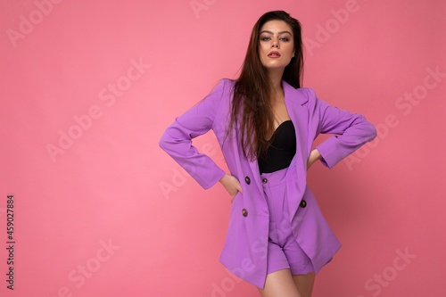 Young sexy brunette woman nice-looking attractive charming elegant fashionable serious isolated over pink color background with empty space for text