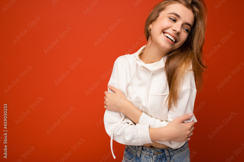 Shot of attractive happy smiling young woman wearing casual outfit standing isolated over colourful background with empty space looking to the side Shot of attractive happy smiling young woman wearing casual outfit standing isolated over colourful background with empty space looking to the side
