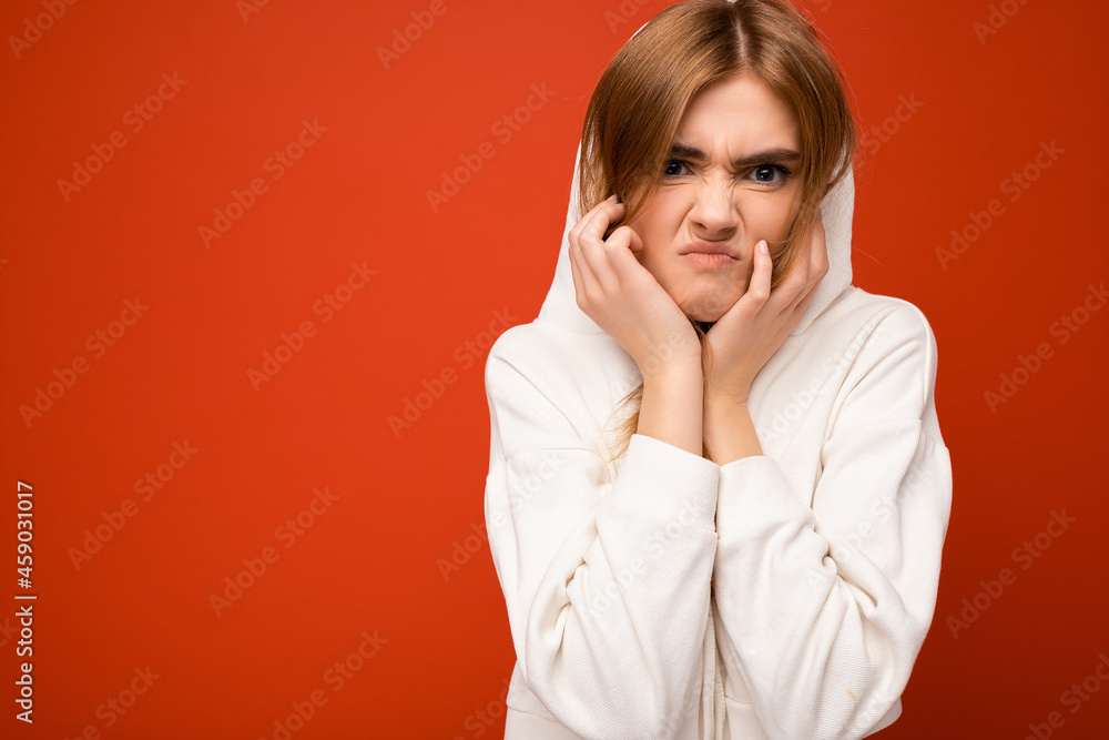 Angry young attractive dark blonde female person with sincere emotions isolated on background with copy space wearing casual hoodie. Negative concept Angry young attractive dark blonde female person with sincere emotions isolated on background with copy space wearing casual hoodie. Negative concept