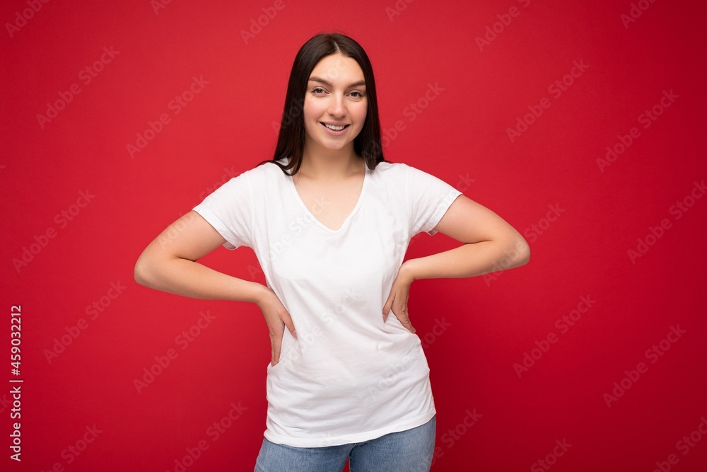 Young smiling pretty brunette woman with sincere emotions isolated on background wall with copy space wearing casual white t-shirt for mockup. Happy concept Young smiling pretty brunette woman with sincere emotions isolated on background wall with copy space wearing casual white t-shirt for mockup. Happy concept