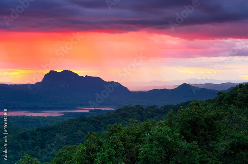 Aerial view rain storms and black clouds moving over the mountains and red light on sunset In the north of Thailand, Pang Puay, Mae Moh, Lampang, Thailand. long exposure.