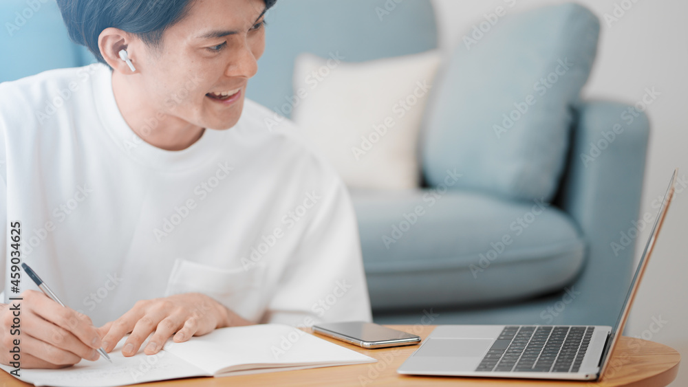ノートパソコンでオンライン授業を受ける男性
