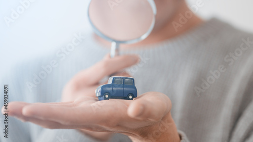 Fotografía 自動車の模型に虫眼鏡を向ける男性