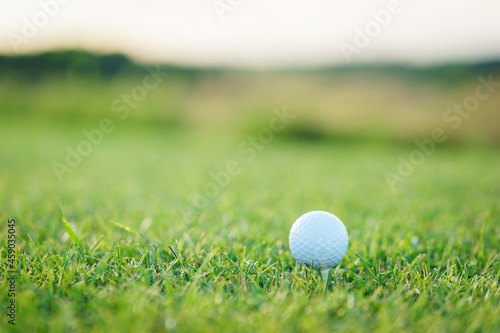Golf ball on green grass on a golf course. Sports equipment close-up.