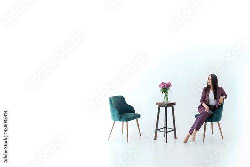 a business woman psychologist in a red suit is sitting opposite an empty chair on a white background