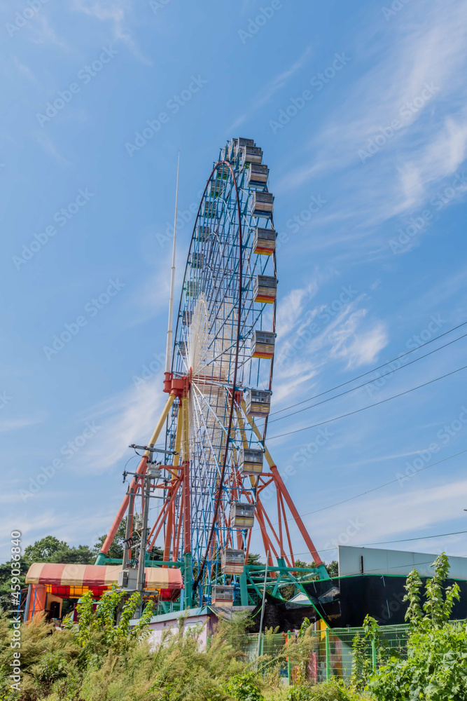 Colorful ferris wheel against blue sky at amusement park.