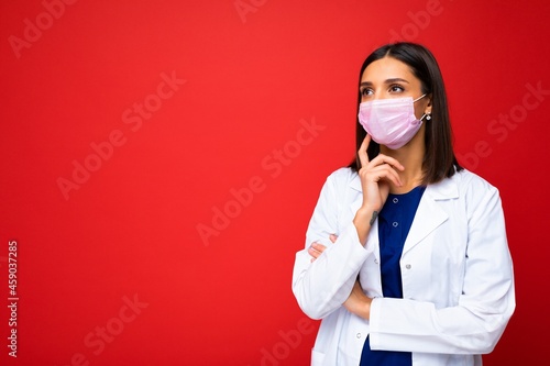 Young woman wearing an anti virus protection mask to prevent others from corona COVID-19 and SARS cov 2 infection isolated over red background