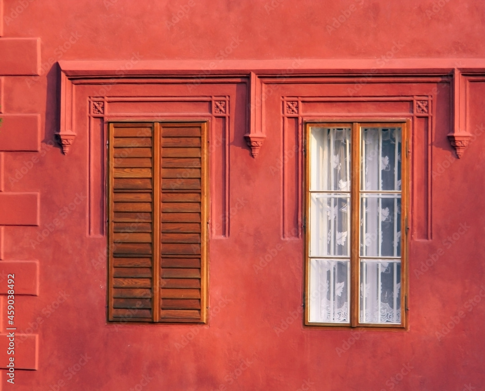 Fototapeta premium Ancient building with two large windows, color detail photography of vintage architecture