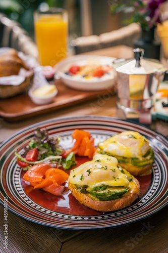 Delicious brunch platter made by two toast of benedict eggs and avocado, with smoked salmon and salad on the side