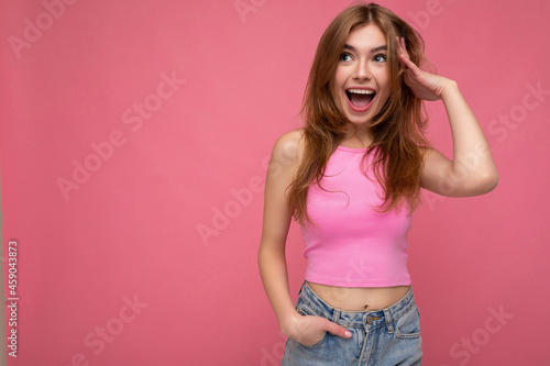 Photo of attractive cute happy surprised emotional young woman poising isolated on background wall with free space wearing trendy casual clothes