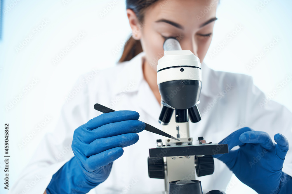 female laboratory assistant looking through a microscope research science technology female laboratory assistant looking through a microscope research science technology