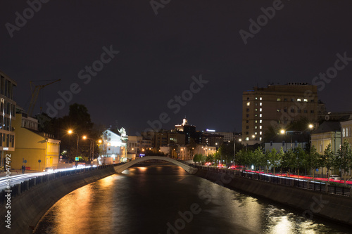 Moscow, Russia, Aug 25, 2021. Night view of Vodootvodny Canal embankment. Car traces. Pedestrian bridge