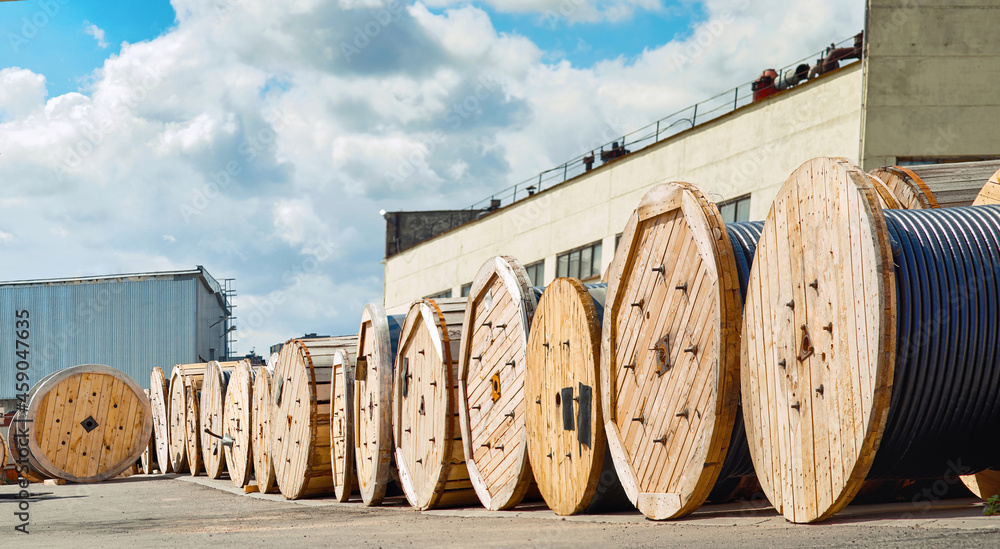 Wooden reels with electrical power cables at stand in row in the
