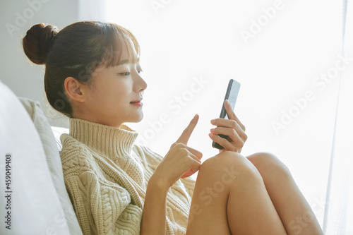 Billede på lærred 自宅でスマートフォンを操作する若い女性
