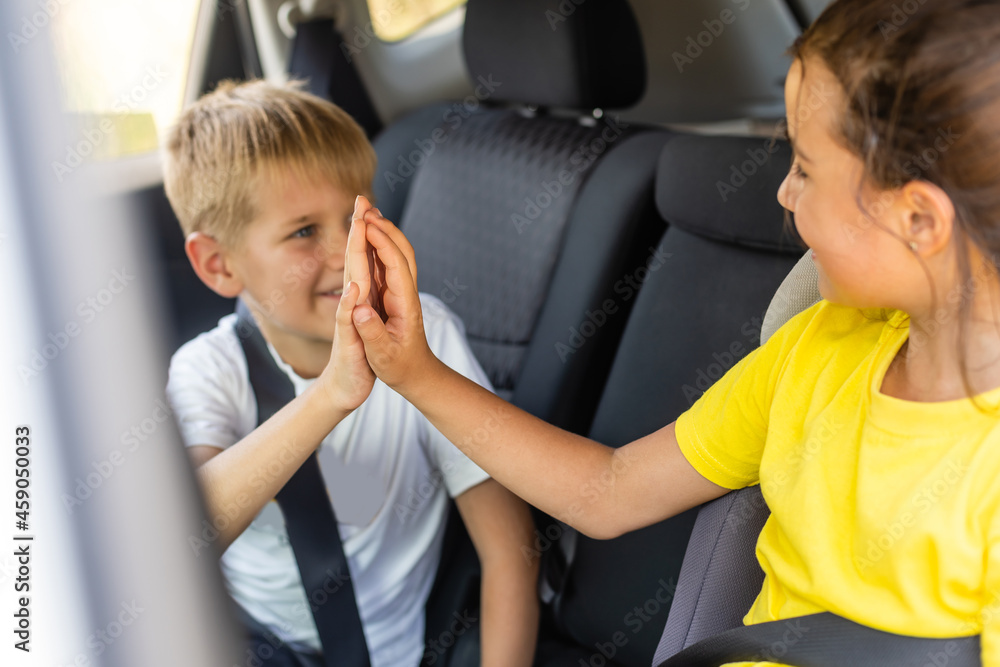 Smiling kids sitting on back seat of car Smiling kids sitting on back seat of car